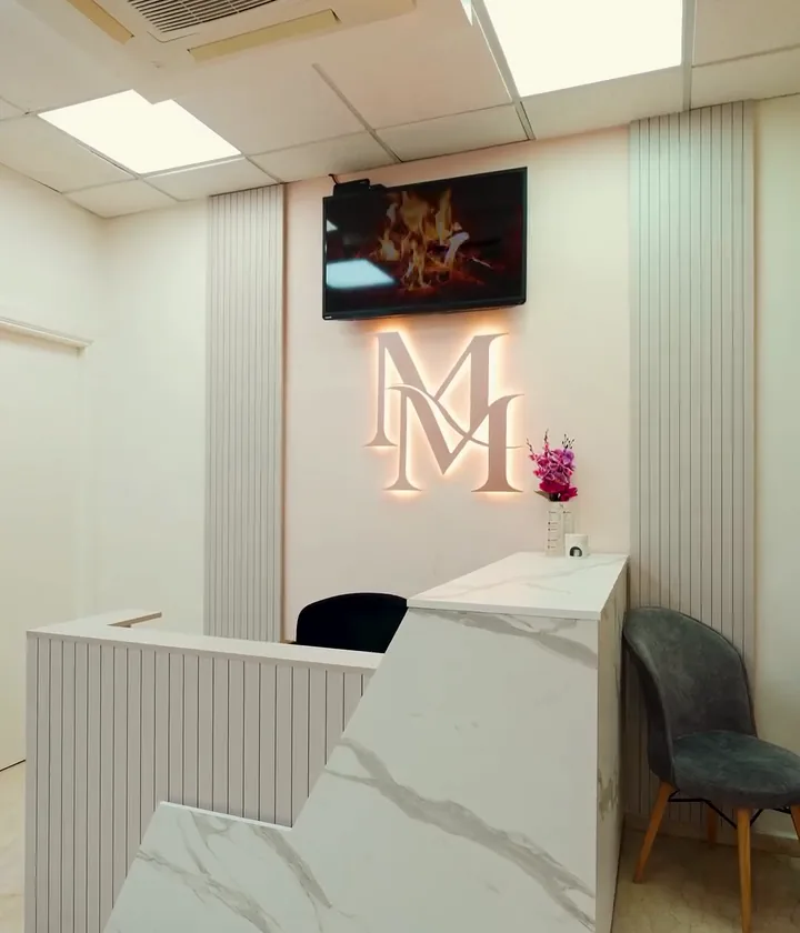 Le comptoir d'accueil en marbre et le monogramme lumineux